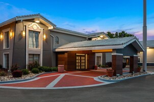 Un hotel con fachada moderna, entrada de ladrillo rojo e iluminación exterior.