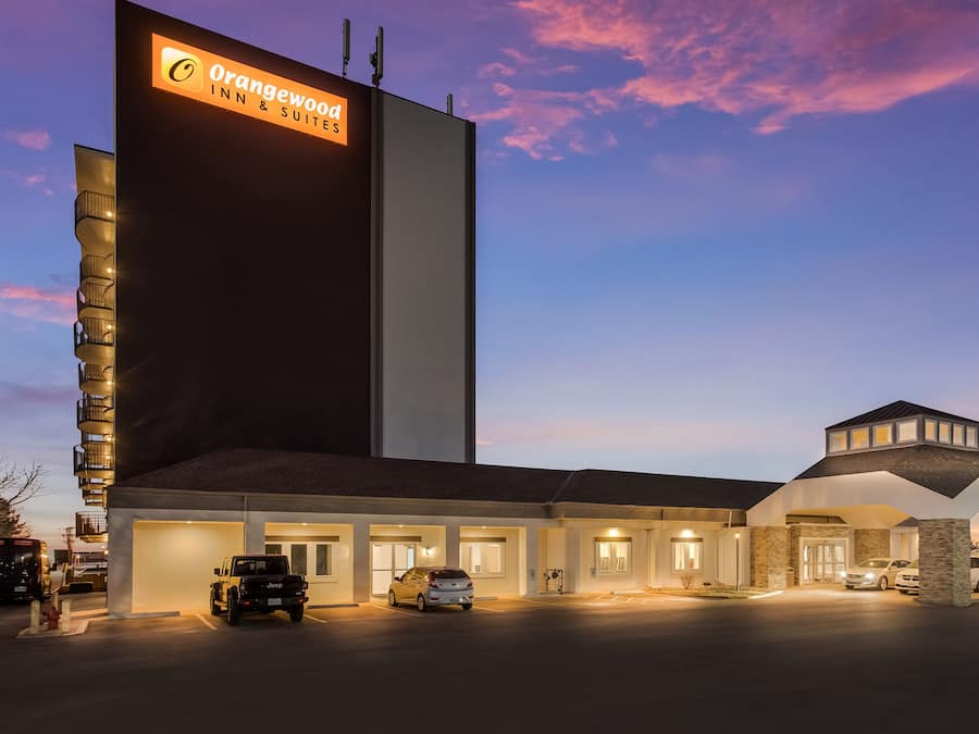 Ein Hotel mit auffälliger Beschilderung, mehreren Parkplätzen und einem überdachten Eingang.