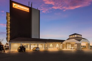 A hotel with a prominent sign, multiple parking spaces, and a covered entrance.