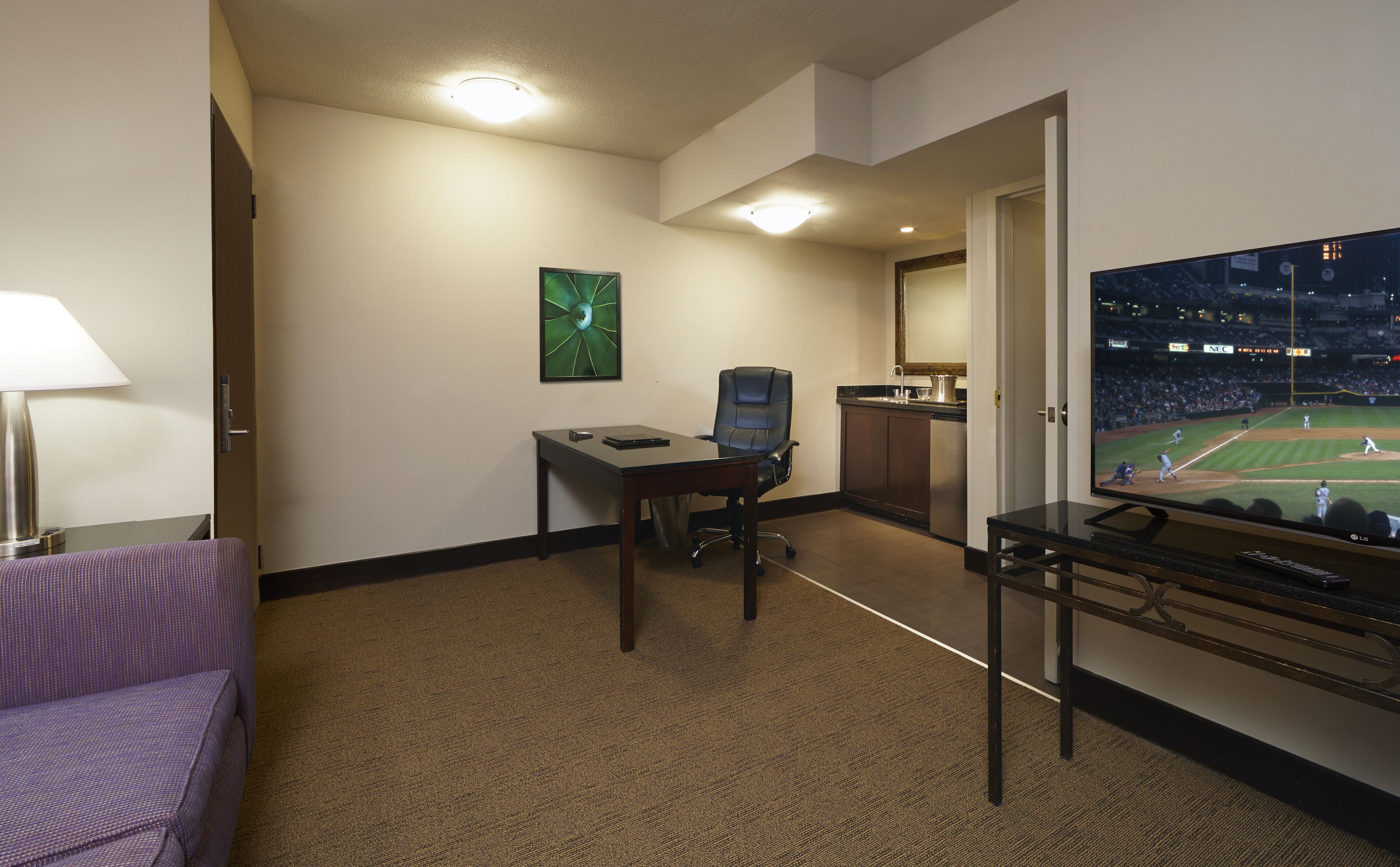 Une chambre d’hôtel équipée d’un bureau, d’une chaise, d’une télévision et d’un lit.