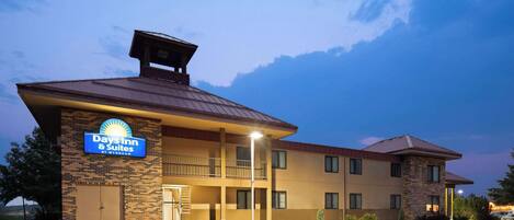 A Day Inn & Suites building with a brick facade, a flat roof, and a sign indicating it is a hotel.