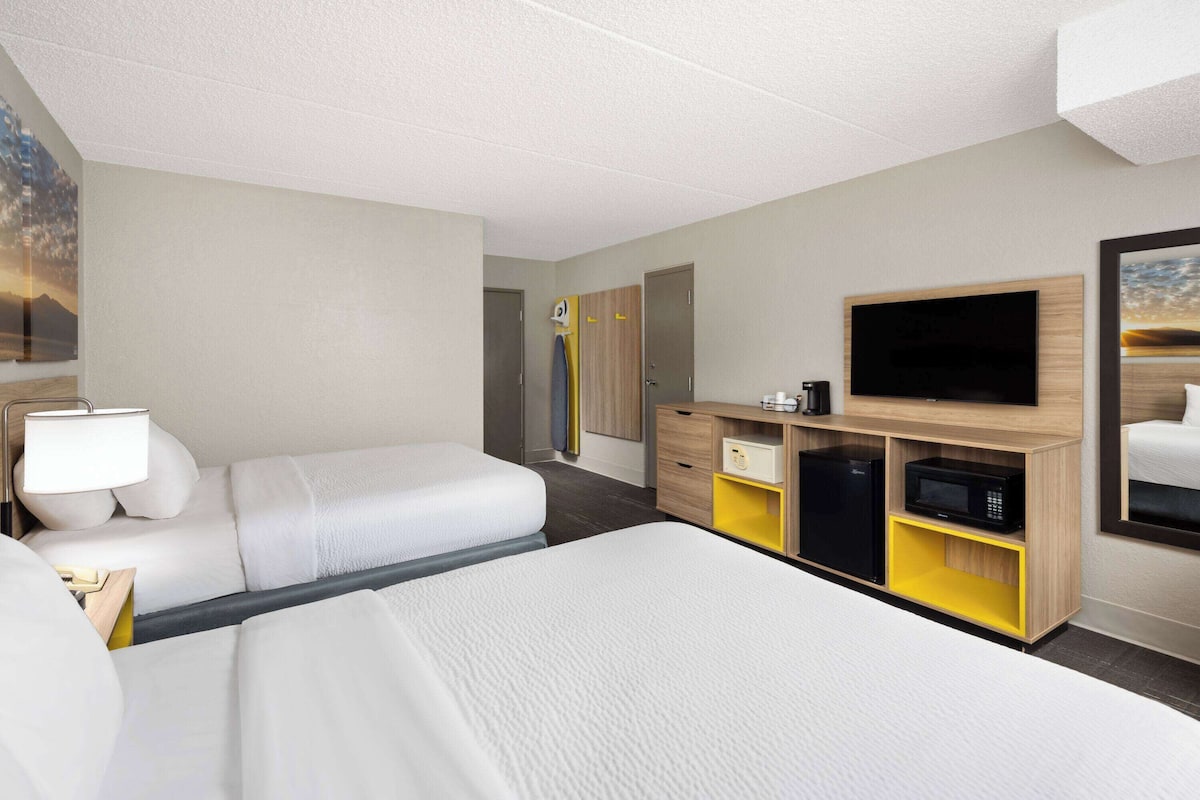 Ett hotellrum med en säng, ett skrivbord, en tv och en garderob.