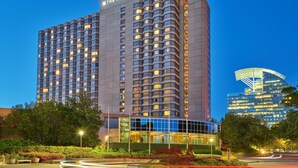 Un hotel di grandi dimensioni con numerosi piani e un design moderno, con un cartello ben visibile in cima.