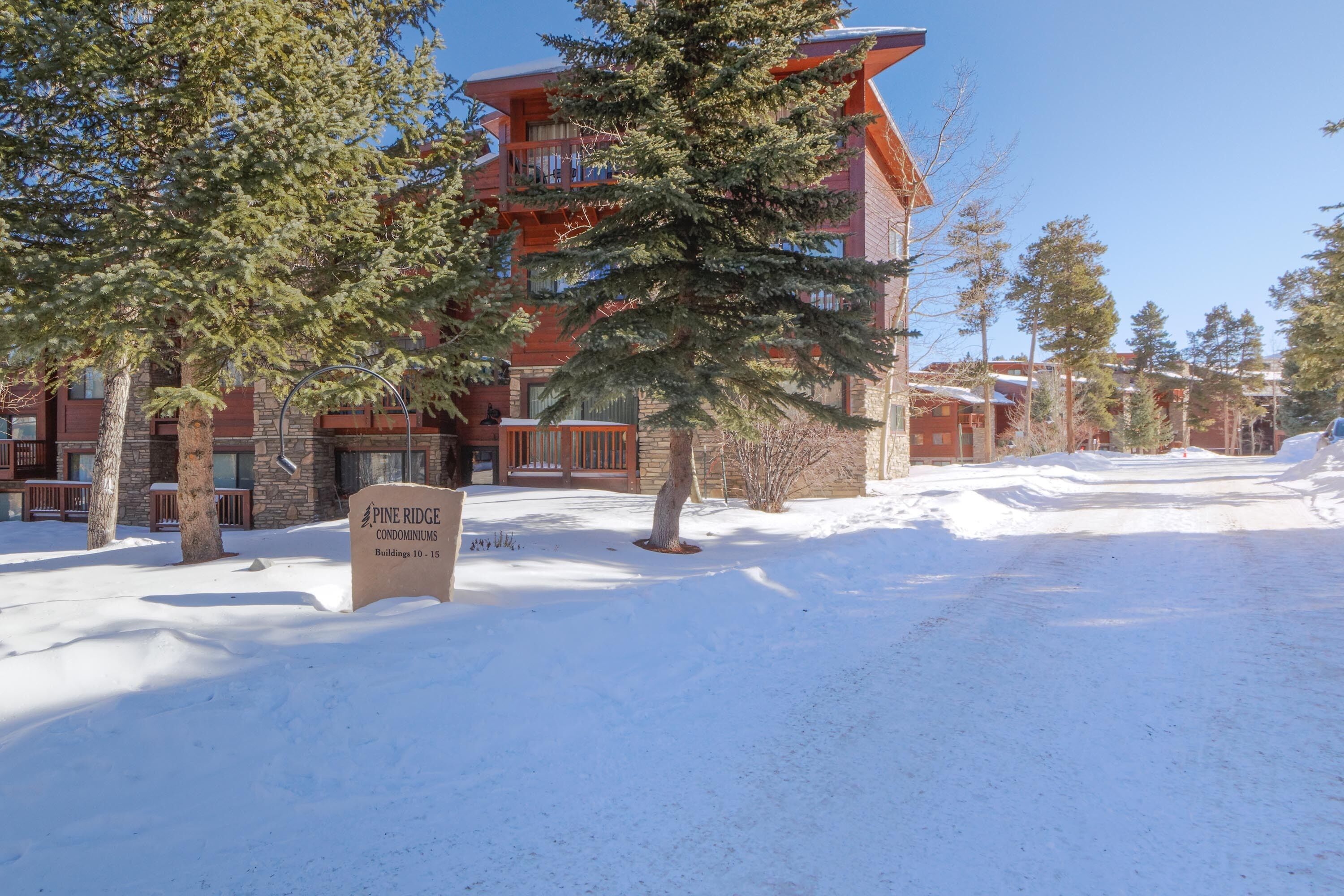 Un bâtiment recouvert de neige, sur lequel on peut lire l’inscription : « Immeubles 10 à 15, résidence Pine Ridge. »