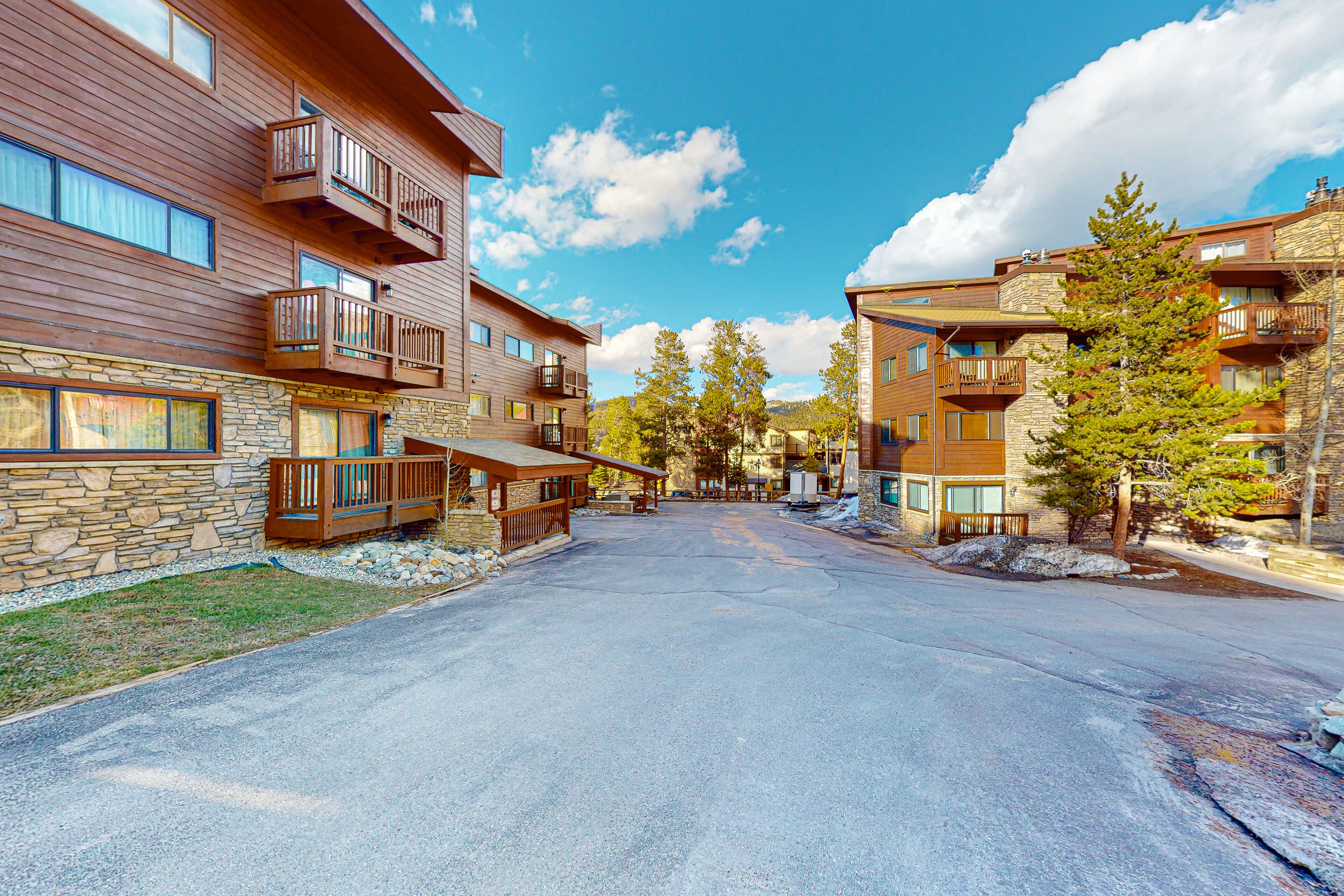 A modern building with multiple balconies, stone facade, and a clear sky.