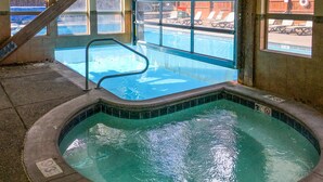 A hot tub with a view of a swimming pool and lounge chairs outside. - Pine Ridge Condominiums (Breckenridge)