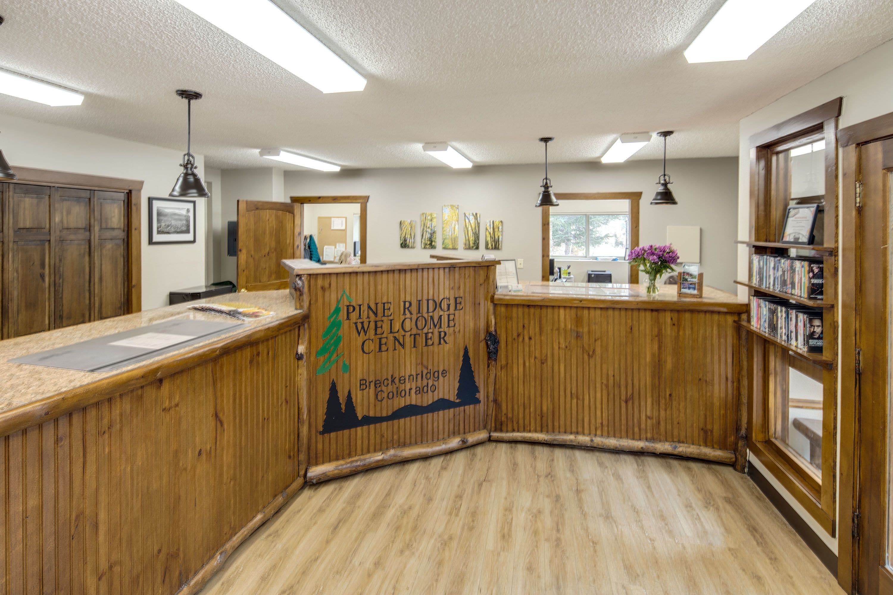 Un centre d’accueil de Pine Ridge doté de lambris en bois, d’un comptoir d’accueil et d’une bibliothèque.