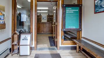 A reception area with a wooden bench, a sign reading "I love Breckenridge because: The People," and a "Late Arrivals" sign.