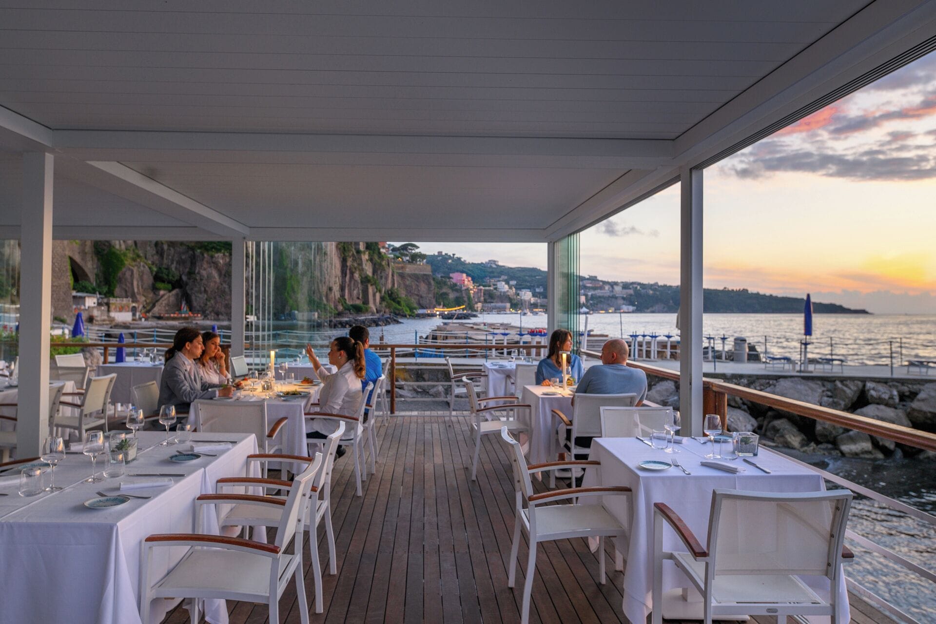 Restaurante com área externa e mesas dispostas para refeições, com vista para a orla.