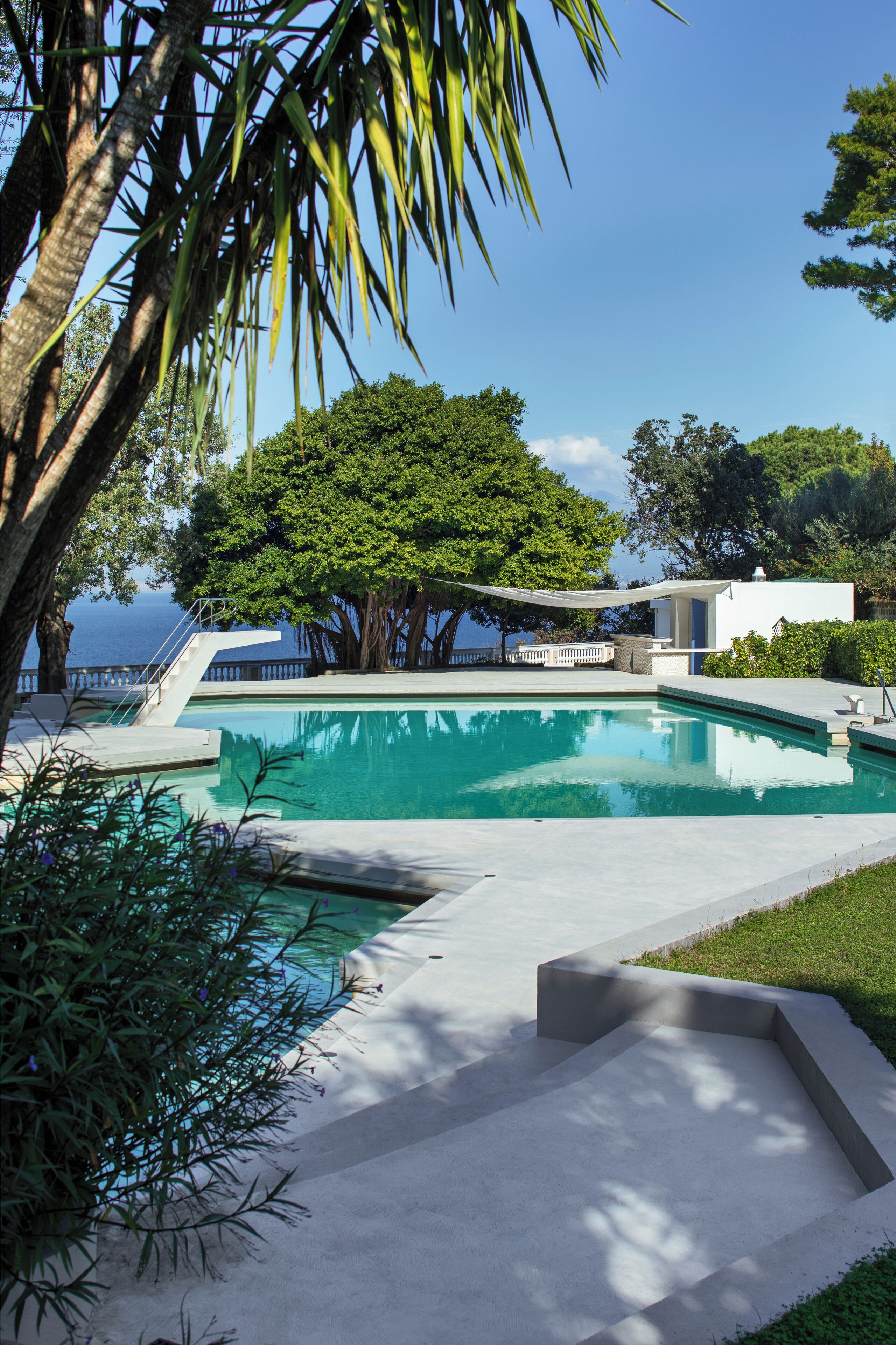 Una piscina al aire libre de temporada, sombrillas, tumbonas