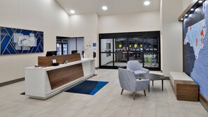 A reception area with a modern desk, seating, and a large map on the wall. - Holiday Inn Express Winston-Salem Medical Center Area by IHG (Winston-Salem)