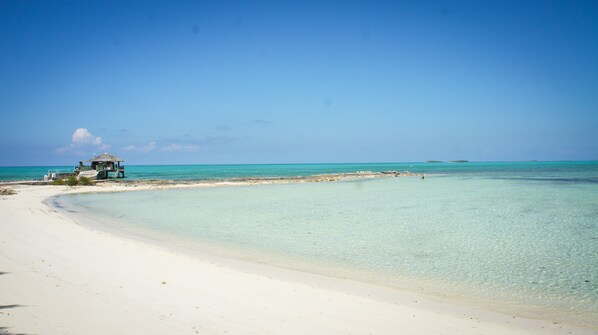 Plage privée, sable blanc, chaises longues, serviettes de plage