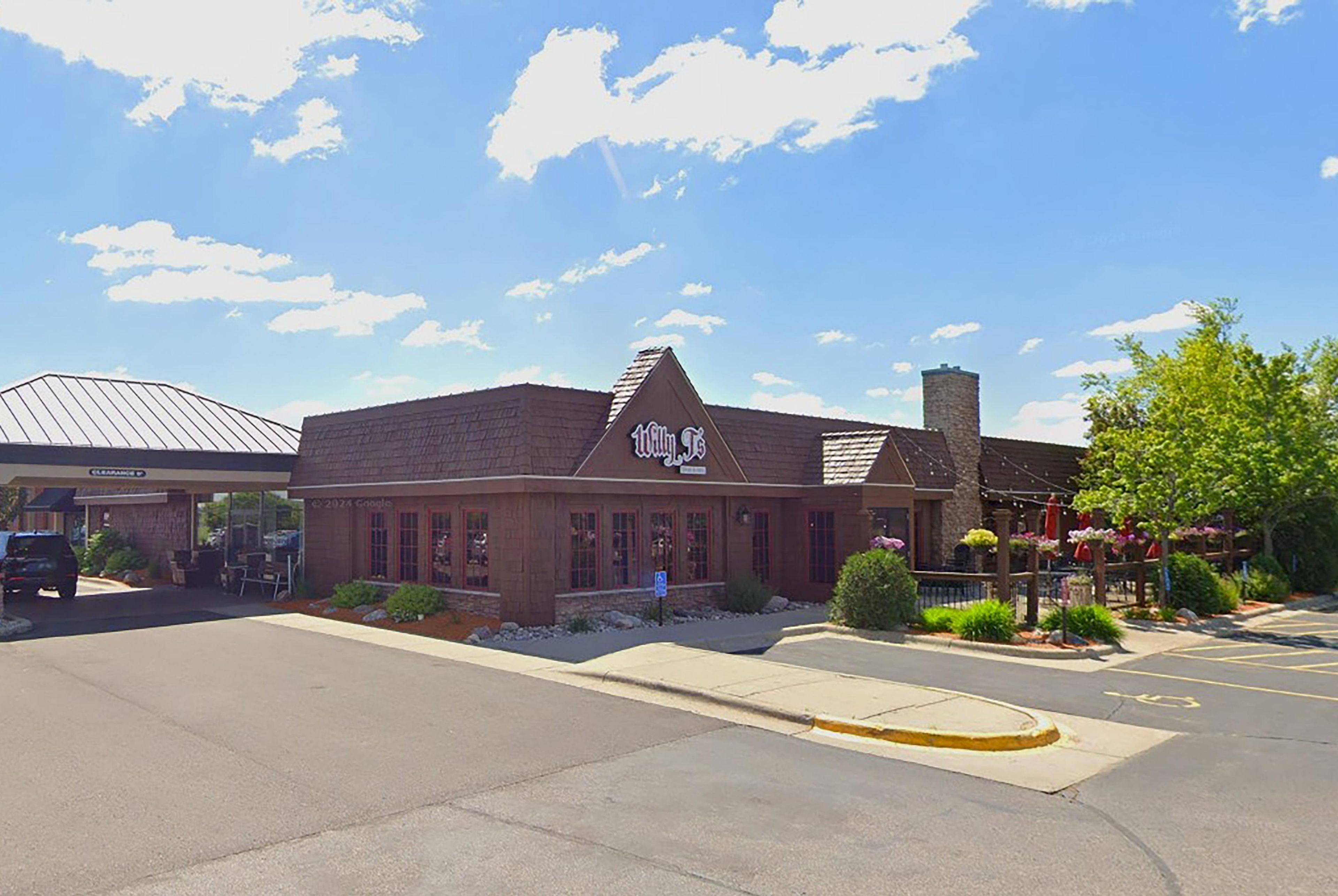 A building with a sign that reads 'Wayne's' and a parking lot in front.