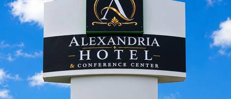 A sign for Alexandria Hotel & Conference Center with a prominent logo and name.