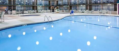 A large indoor swimming pool with multiple levels of balconies and seating areas.