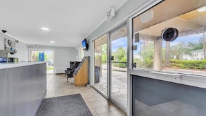 A reception area with a counter, a staircase, and a view of the outside.