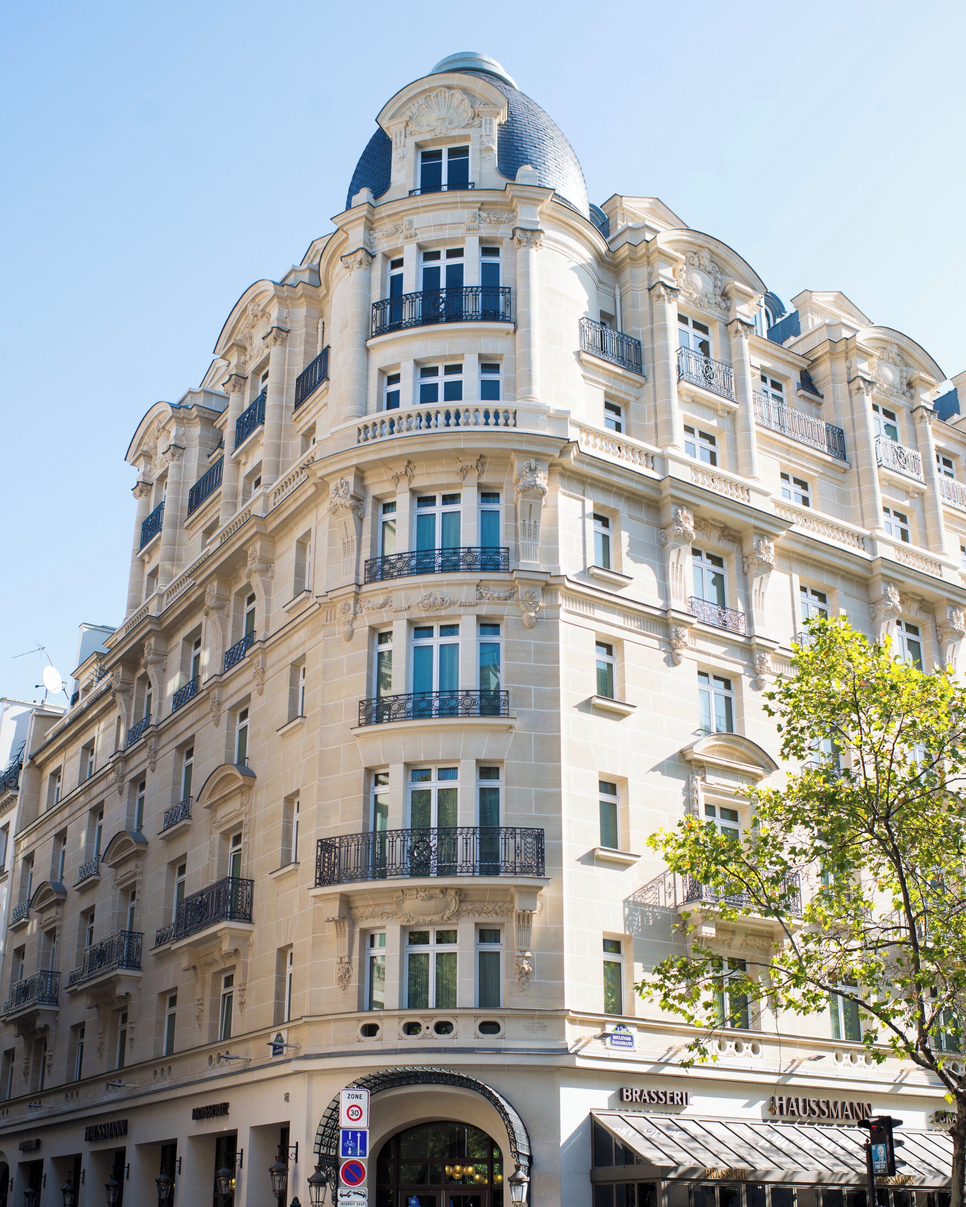 Un edificio de varios pisos con arquitectura clásica, que presenta balcones, ventanas amplias y una cúpula en la parte superior.