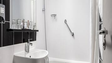 A modern bathroom with a white sink, a bathtub, and a shower.