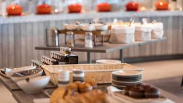 A buffet setup with various food items and condiments.