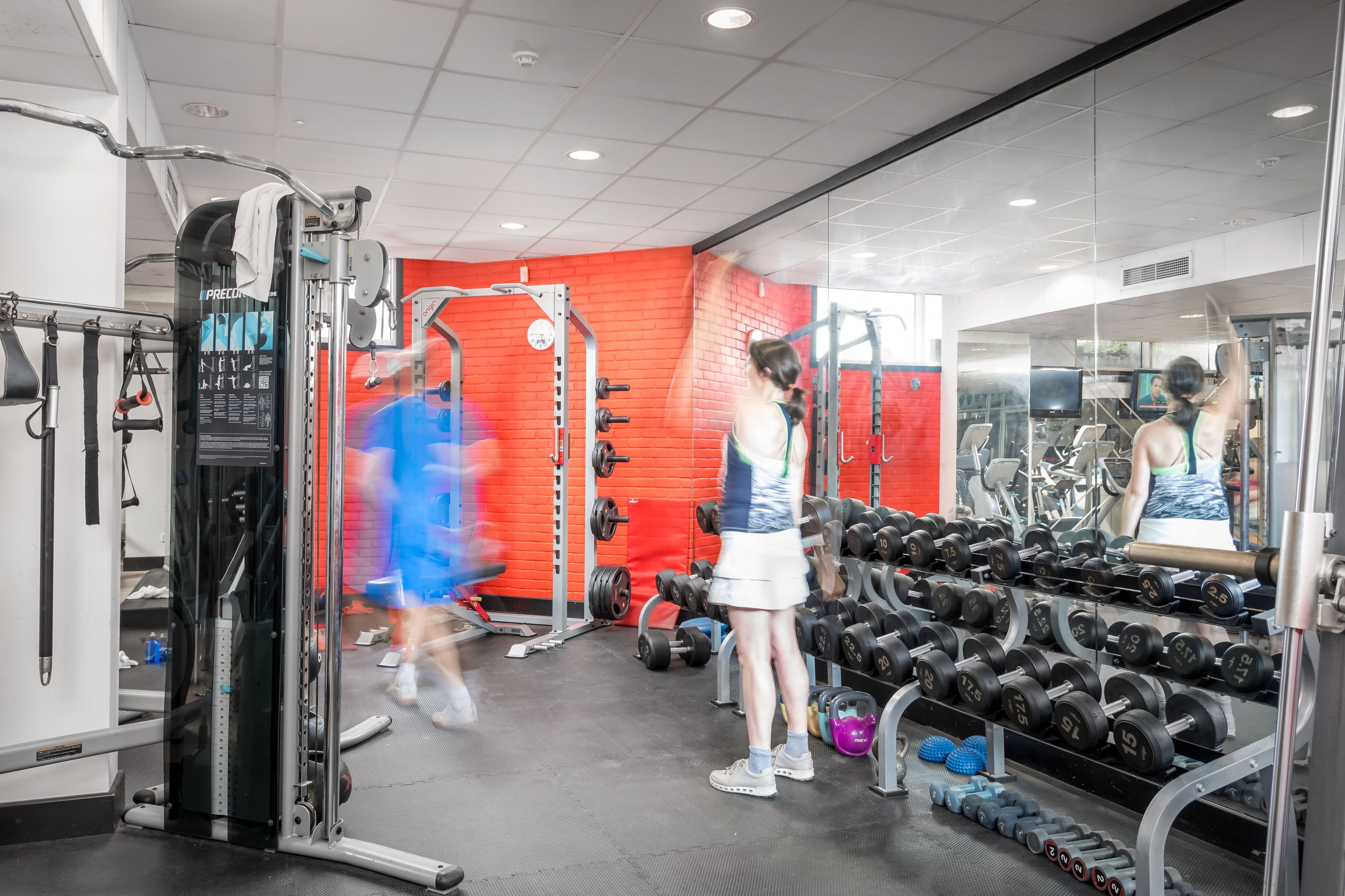 A gym with various exercise equipment, including dumbbells and weight machines.