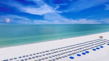 On the beach, white sand, sun loungers, beach umbrellas