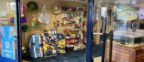 A store with a variety of sports equipment and accessories, including balls, hats, and bags.
