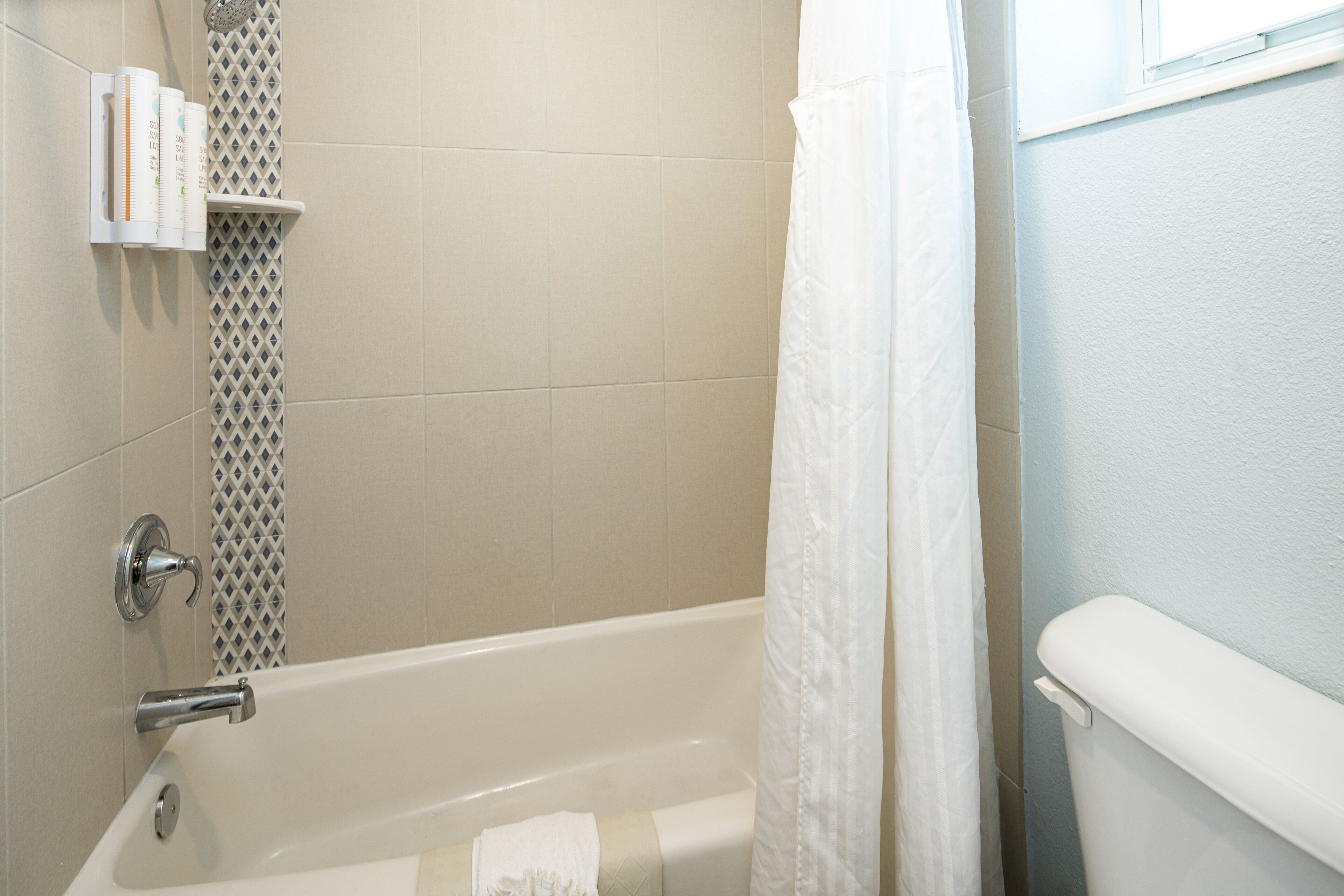 Une salle de bain avec une baignoire, un rideau de douche et des toilettes.