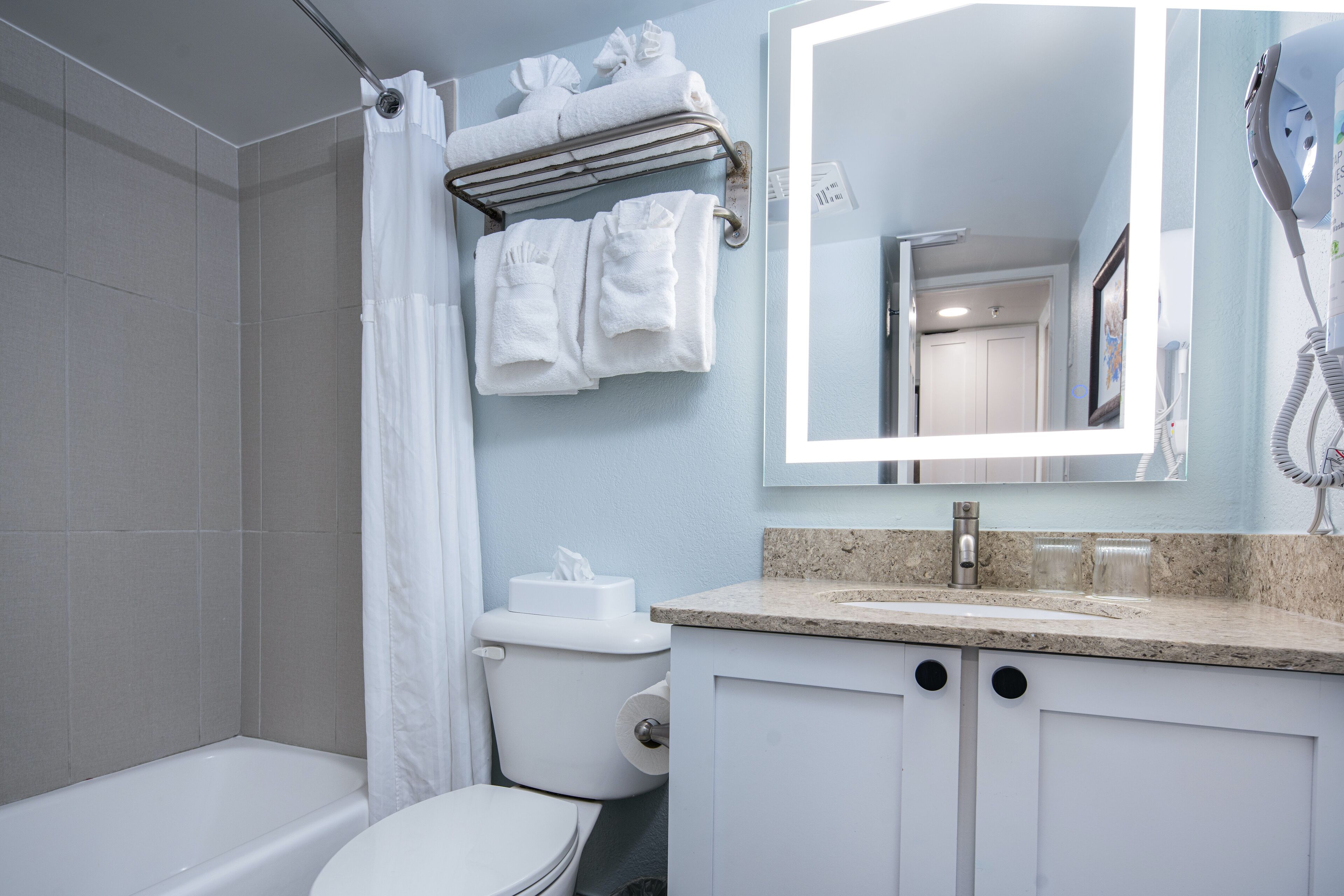 Une salle de bain équipée d’une baignoire, de toilettes et d’un lavabo avec un miroir au-dessus.