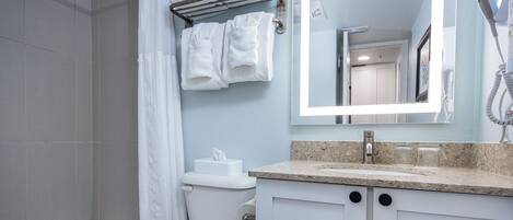 Une salle de bain équipée d’une baignoire, de toilettes et d’un lavabo avec un miroir au-dessus.