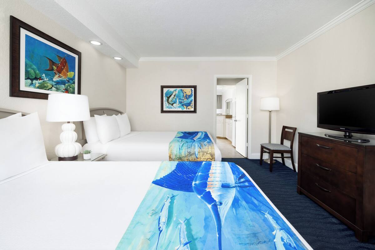 A hotel room with a bed, a TV, a desk, and a chair.