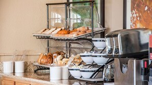 A buffet setup with various baked goods and breakfast items. - Comfort Inn Fergus Falls (Fergus Falls)
