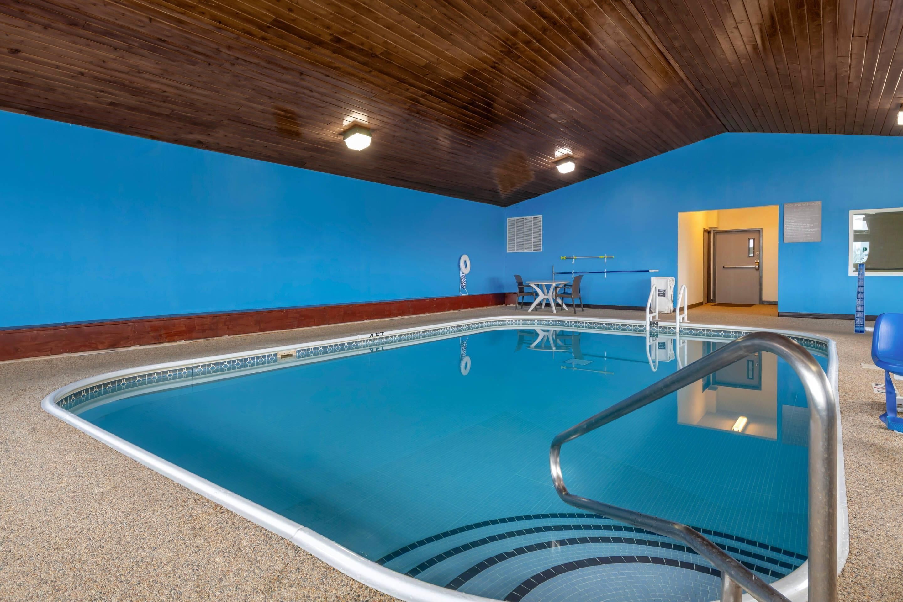 Une piscine avec un plafond en bois, un mur bleu et une porte donnant sur une autre pièce.