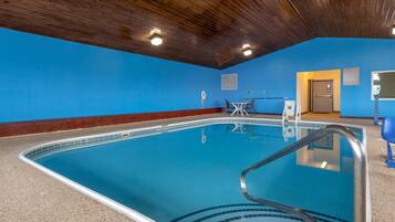 Une piscine avec un plafond en bois, un mur bleu et une porte donnant sur une autre pièce.