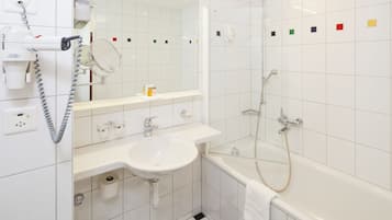 Une salle de bain avec un lavabo, un miroir et une douche.