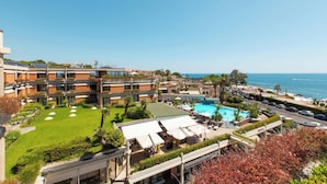 A hotel with multiple floors, a swimming pool, and a view of the sea. - Four Points by Sheraton Catania Hotel & Conference Center (Aci Castello)
