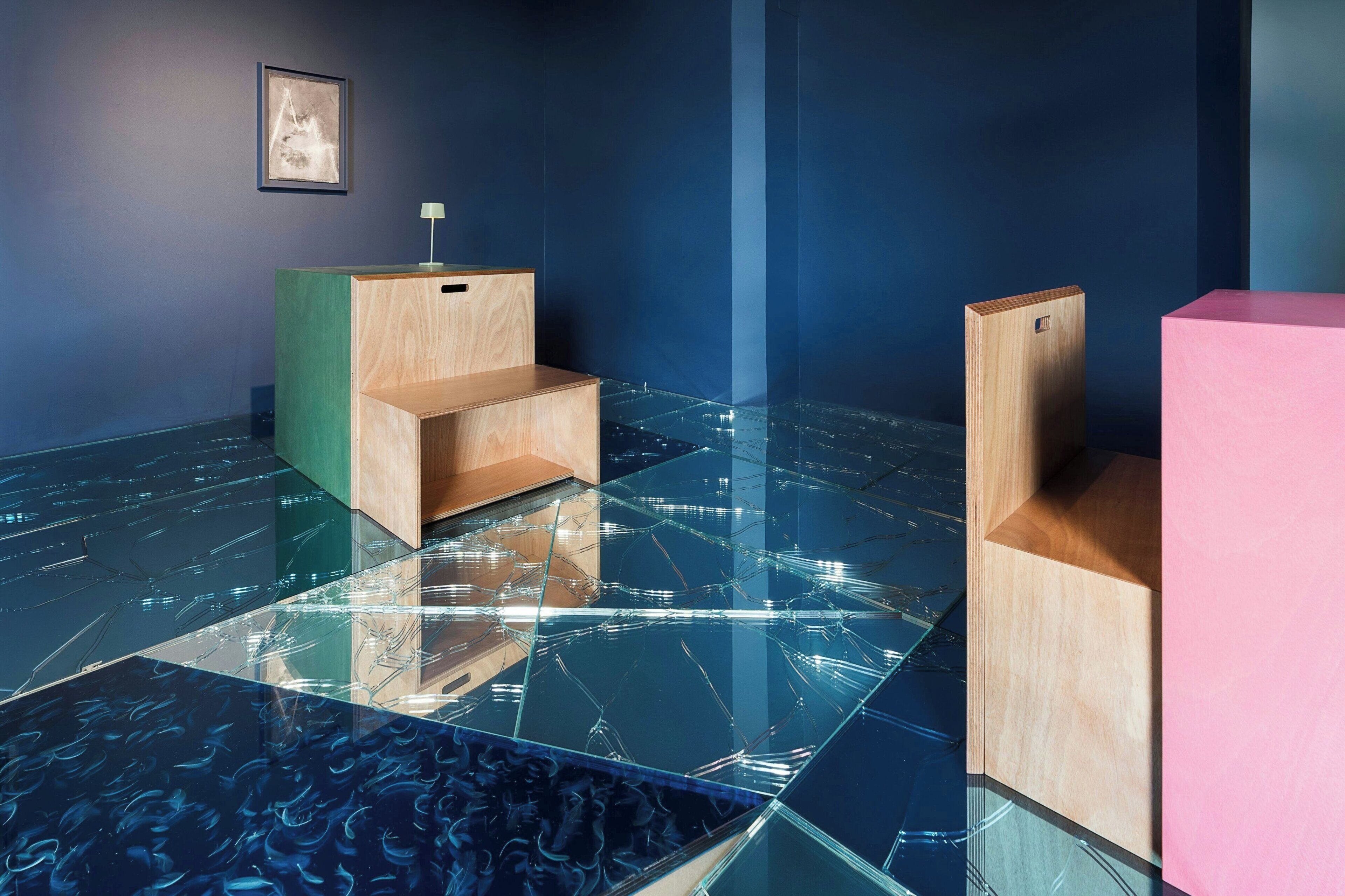 A room with a glass floor, wooden furniture, and a framed picture on the wall.
