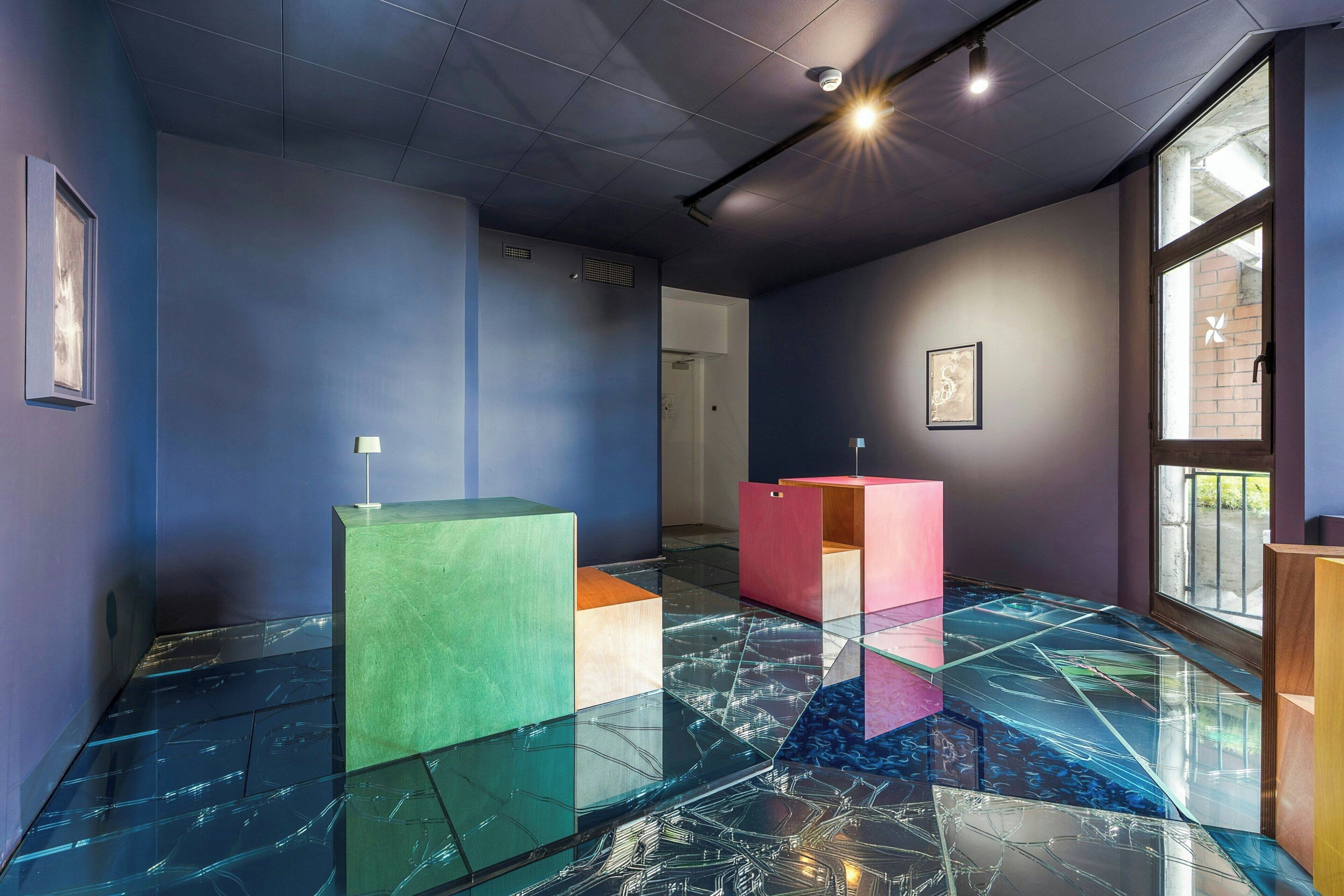 A modern interior with a glass floor, geometric furniture, and large windows.