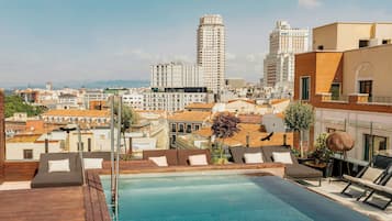 Una piscina al aire libre de temporada, sombrillas, tumbonas