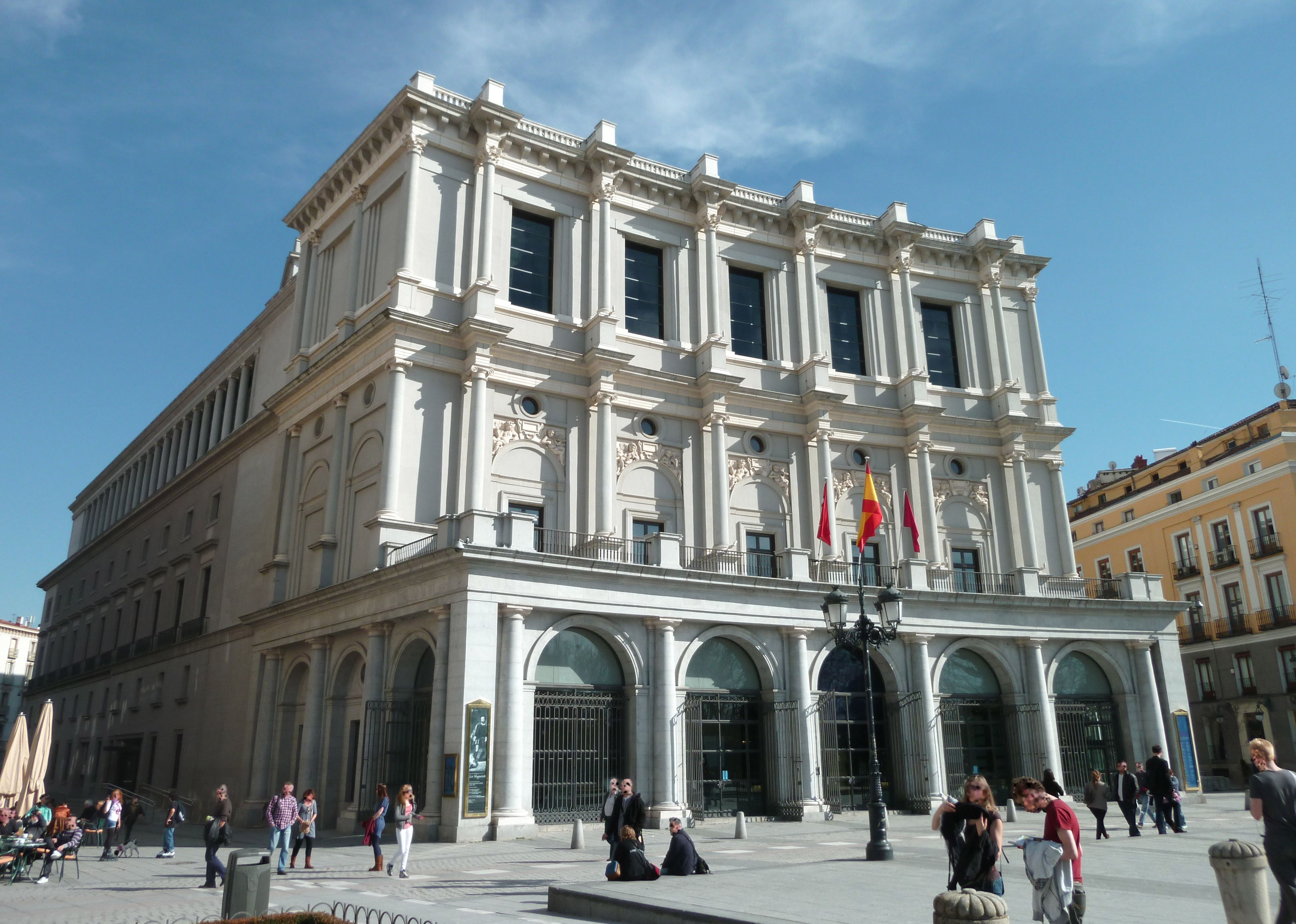 Um edifício grande e histórico com arquitetura clássica, com colunas e janelas em arco.