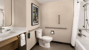 Un baño moderno con inodoro, lavamanos y zona de ducha.