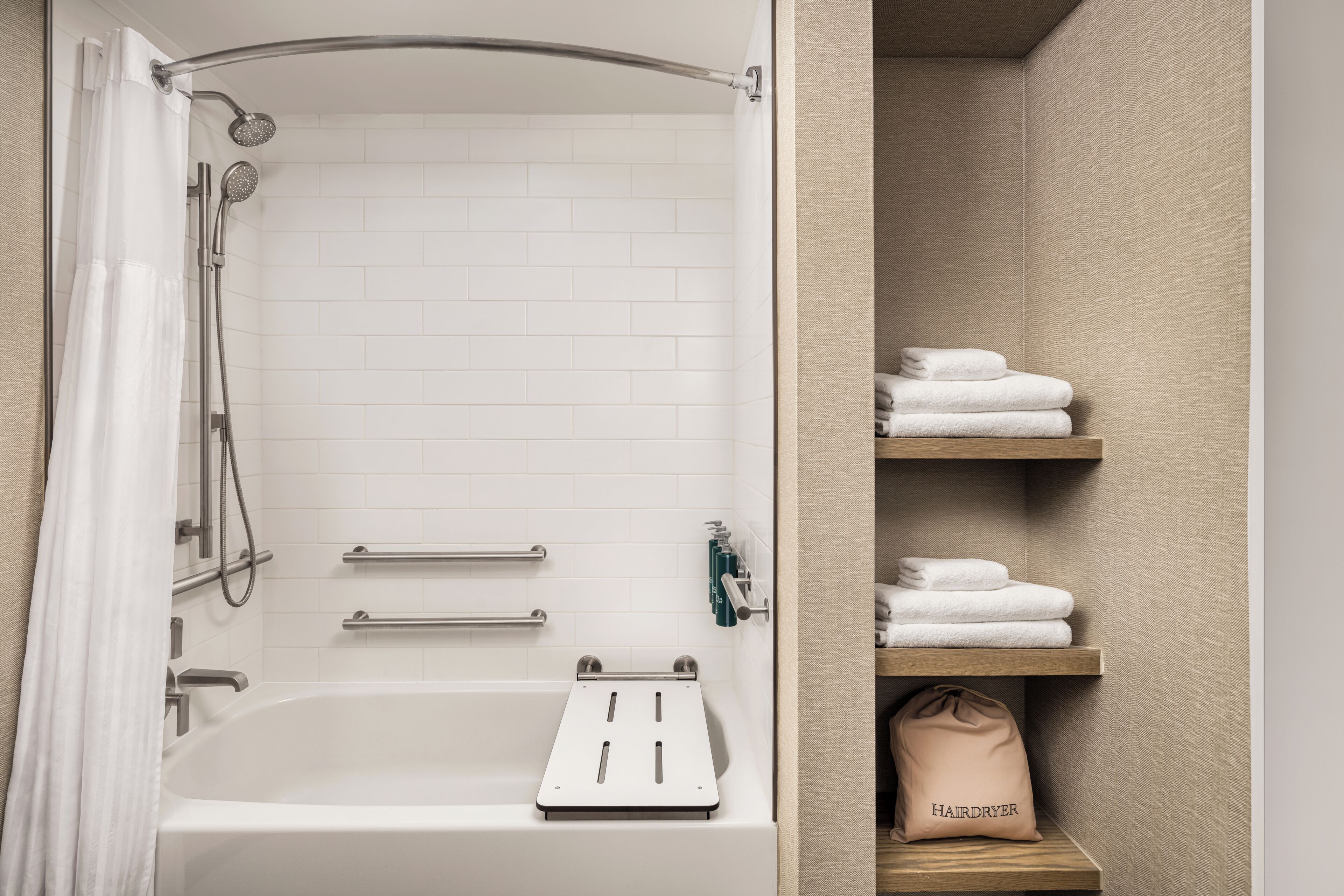 A bathroom with a bathtub, shower, and towel storage.