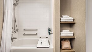 A bathroom with a bathtub, shower, and towel storage. - Hilton Fort Wayne at the Grand Wayne Convention Center (Fort Wayne)