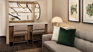 Une chambre d’hôtel moderne équipée d’une kitchenette, d’un canapé et d’un coin repas.