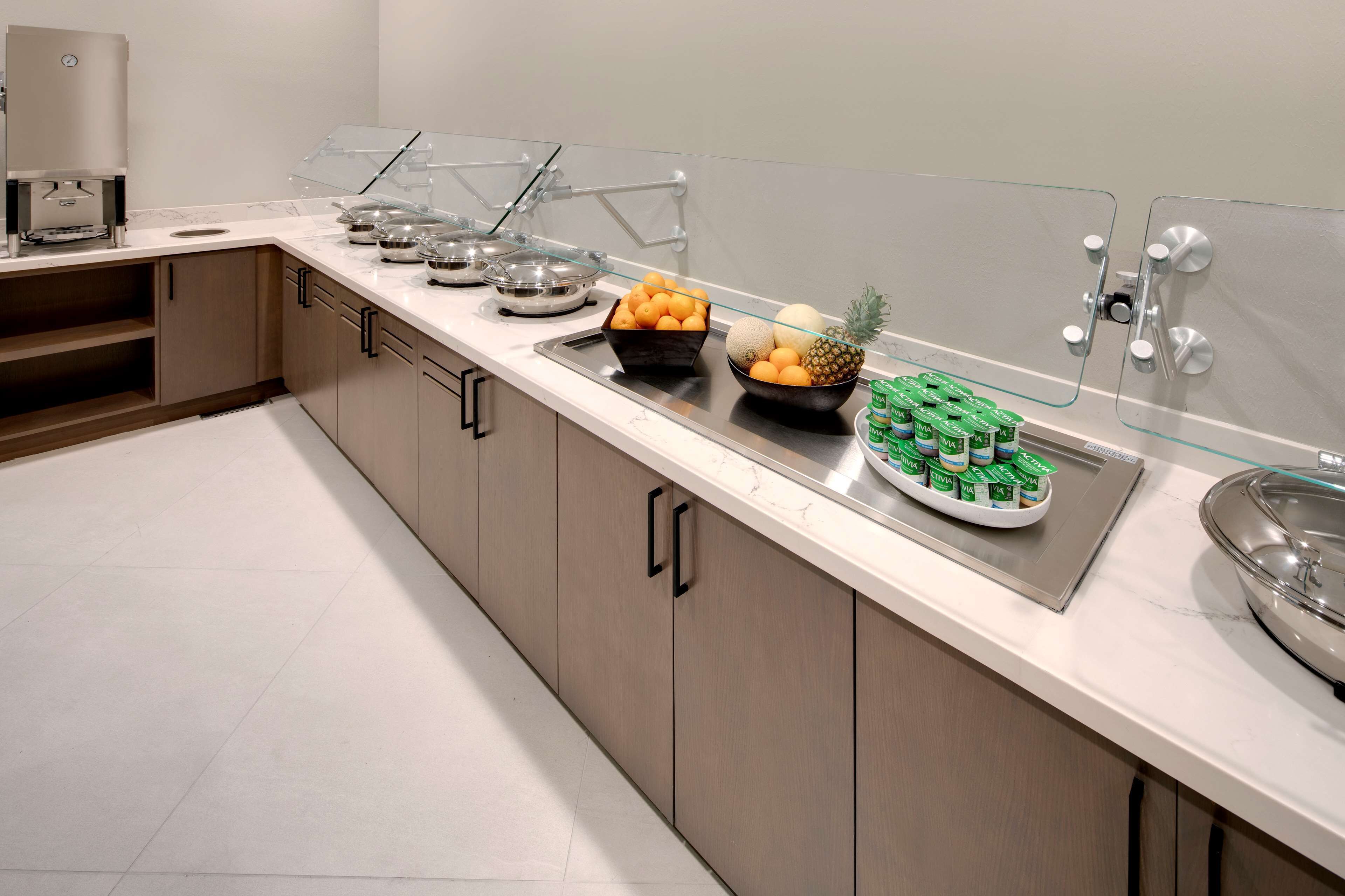A buffet setup with various food items and a coffee machine.