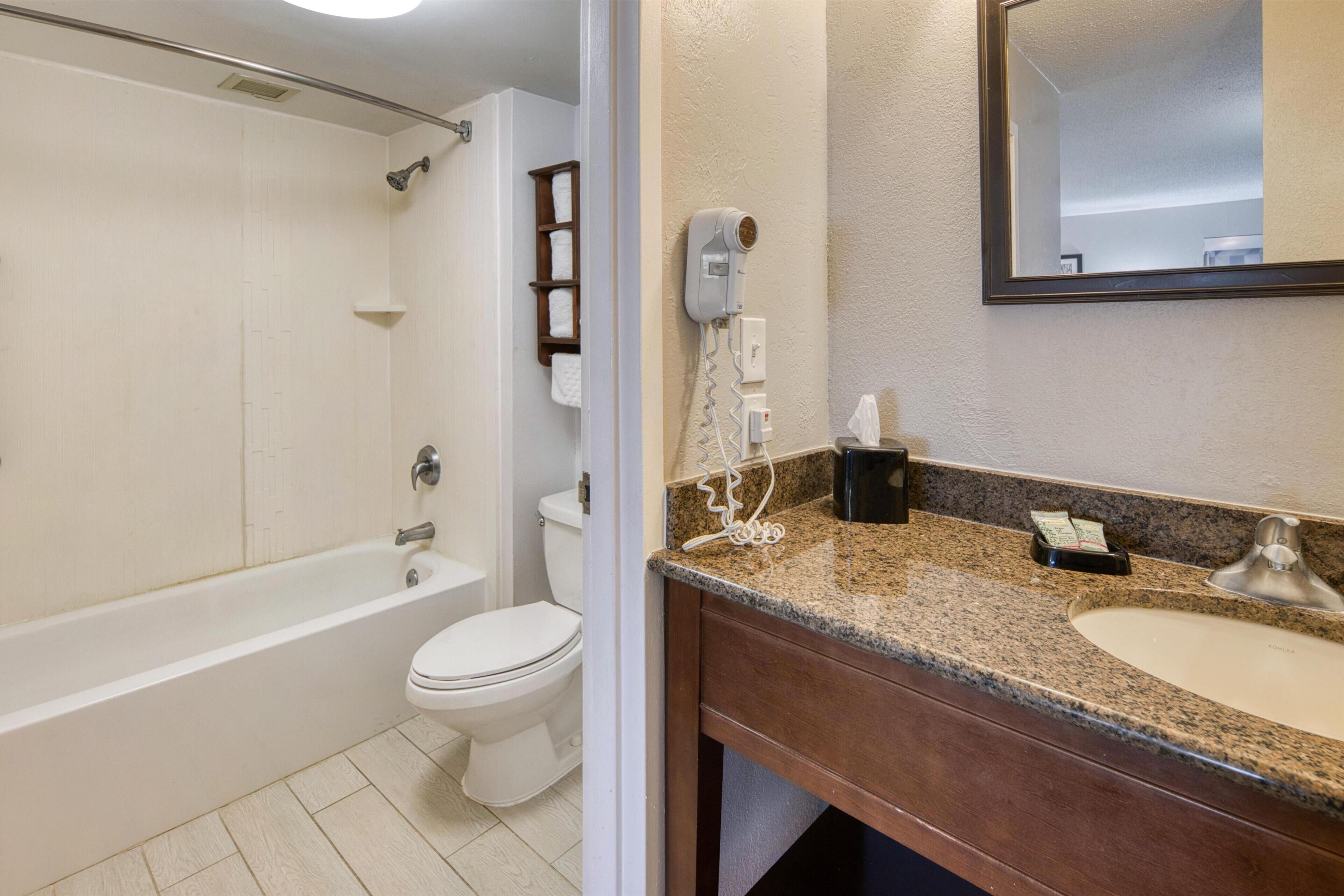 A bathroom with a bathtub, toilet, and sink.