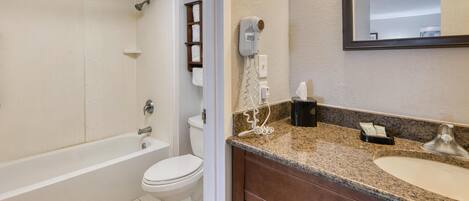 A bathroom with a bathtub, toilet, and sink.