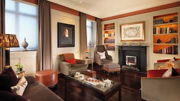 Una sala de estar elegante con chimenea, estanterías y asientos cómodos.