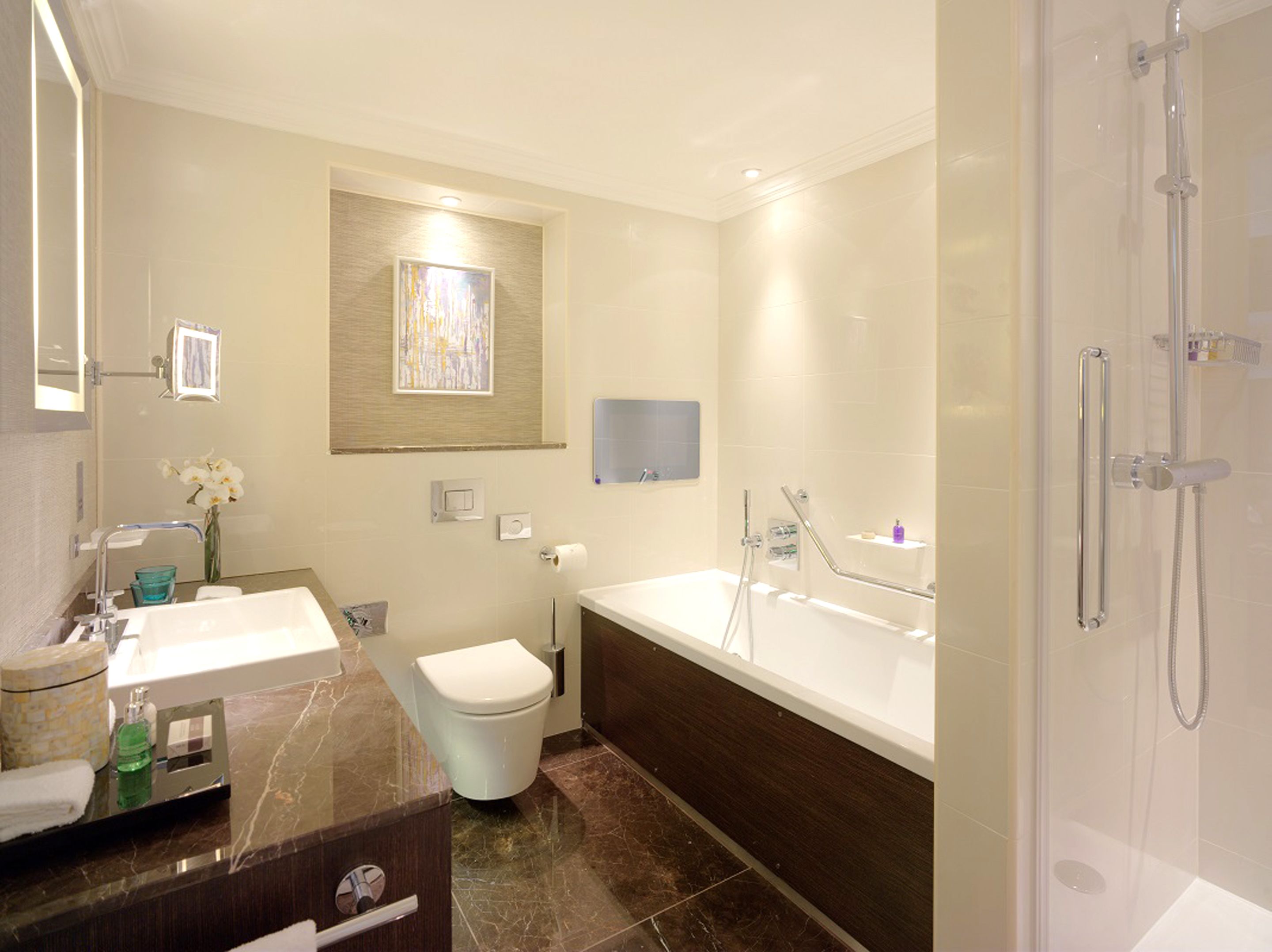 A modern bathroom with a vanity, toilet, bathtub, and shower.