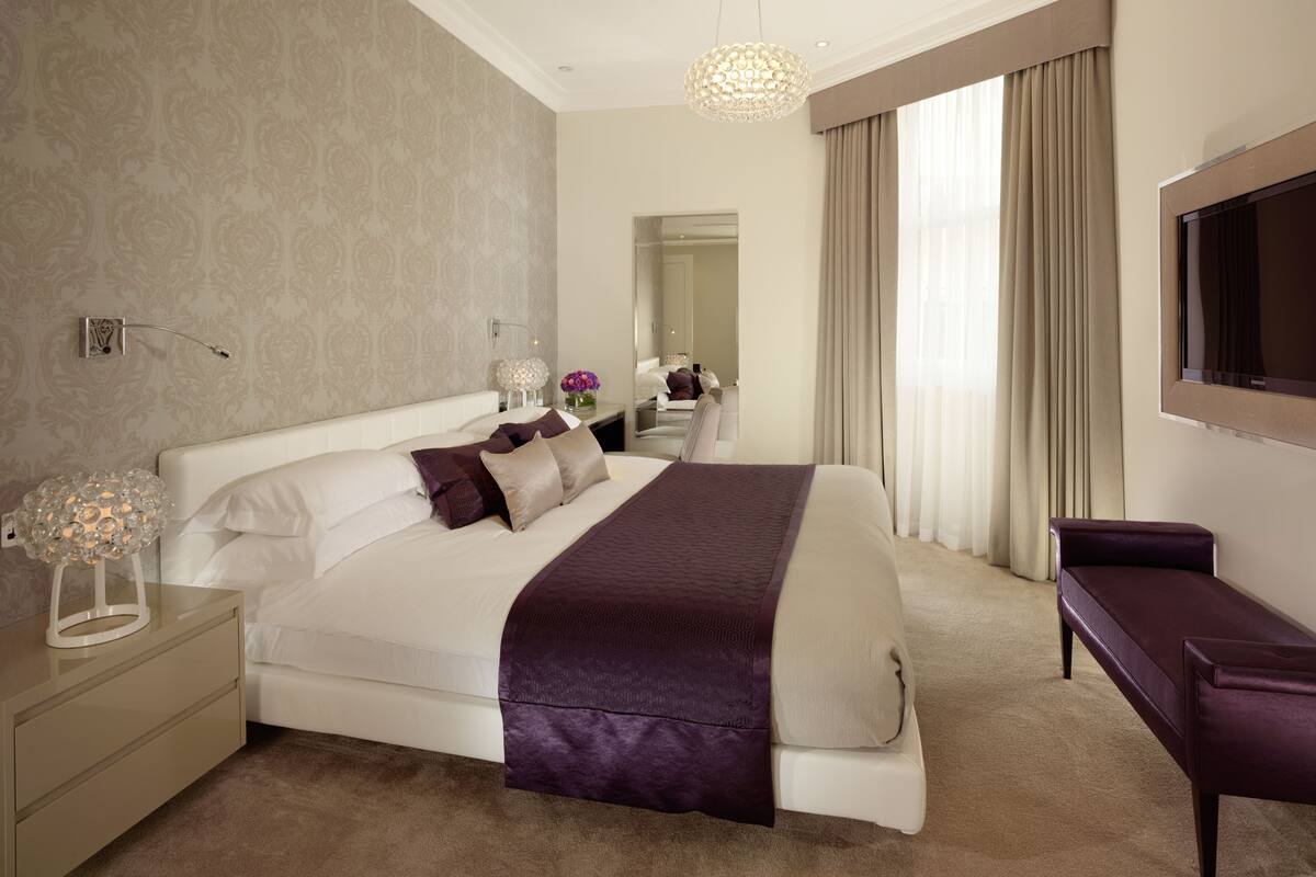 Une chambre d’hôtel moderne dotée d’un grand lit, d’une télévision à écran plat et d’un coin salon.