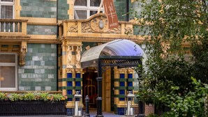 A historic building with ornate architecture, a prominent entrance, and a flag indicating it is a Taj hotel. - Taj 51 Buckingham Gate, Suites and Residences (London)